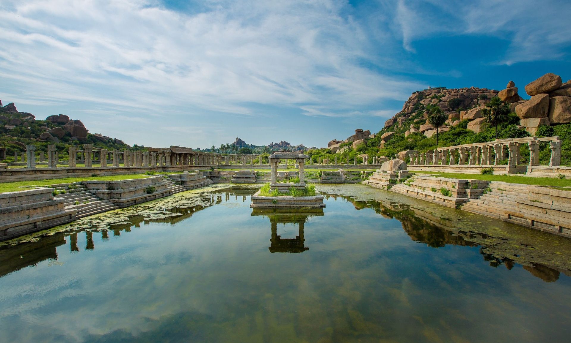 Achyutaraya Temple tank in Hampi with ruins reflected.