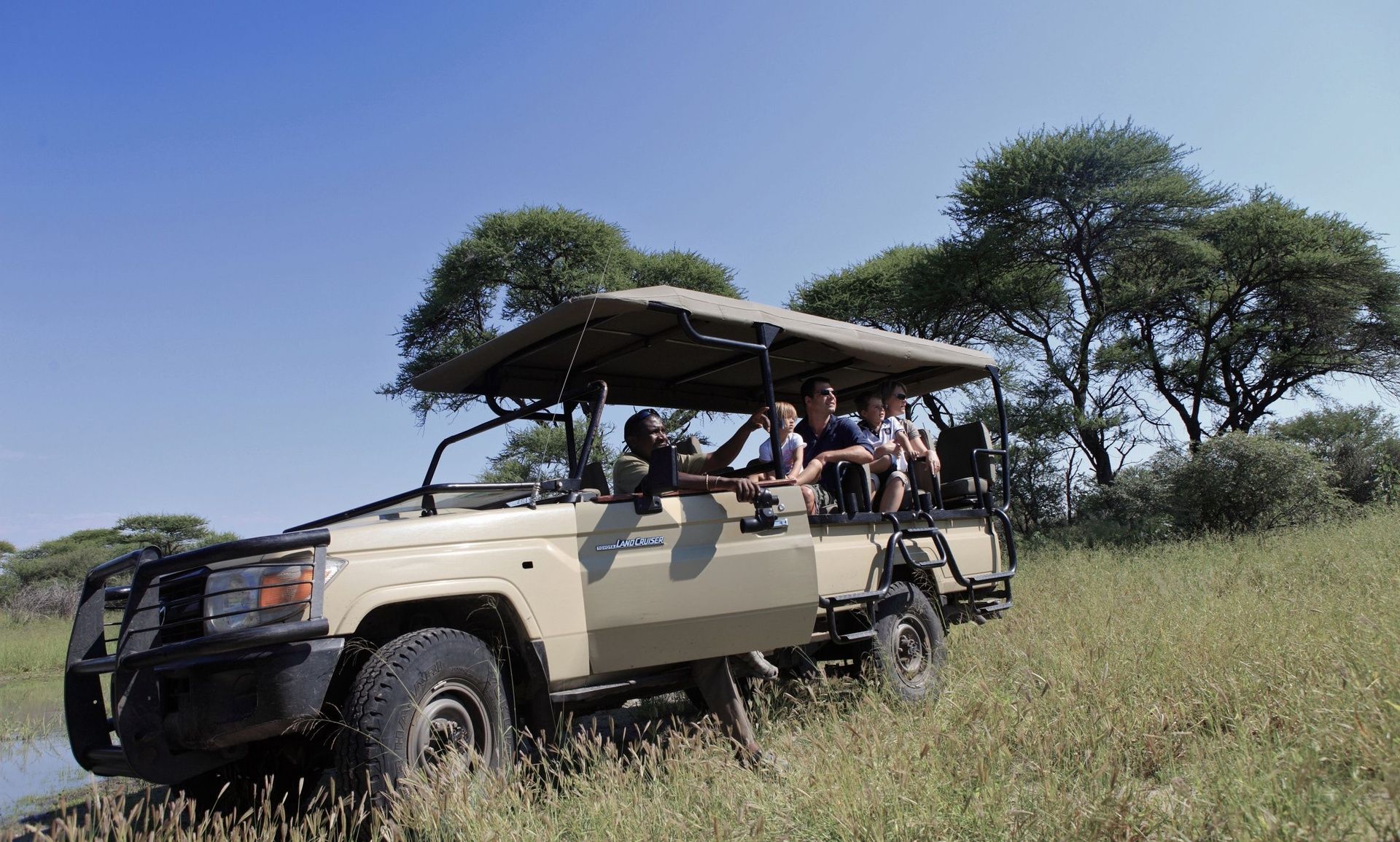 Safari vehicle with people on a game drive.