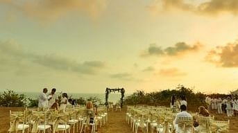 Neatly arranged chairs in an outdoor wedding venue at Fort Tiracol with an aisle leading up to an altar.