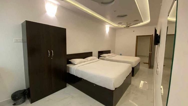 Room with twin beds and a wardrobe at La Paradise Luxury, Pondicherry