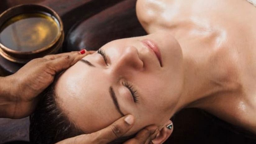 A woman receiving traditional Ayurvedic head massage at YO1 Health Resort, Catskills, New York.