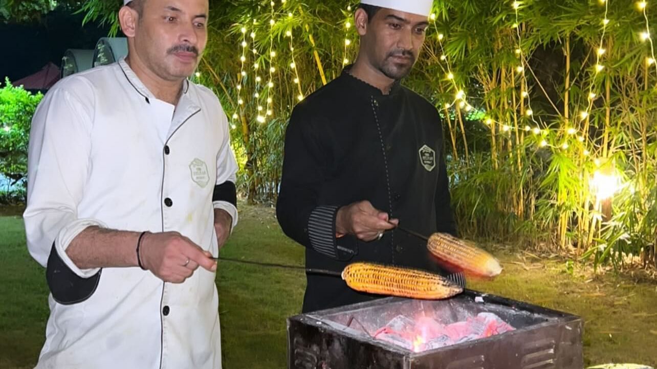 Two chefs preparing barbecue at night at  The Sylvan Retreat, Dehradun.