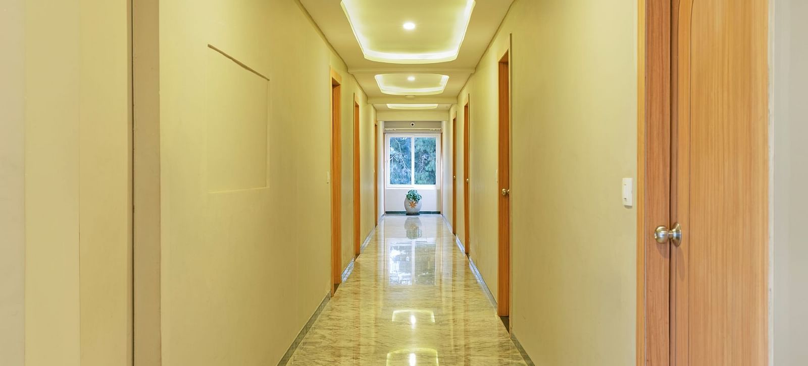Long corridor in a modern building with marble floors and ceiling lights | Mango HIll Central, Ooty