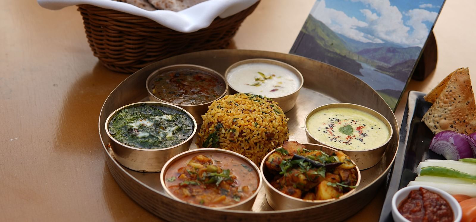 Kumaoni Thali being served in a restaurant at Saraca Resort & Spa Corbett on a wooden table