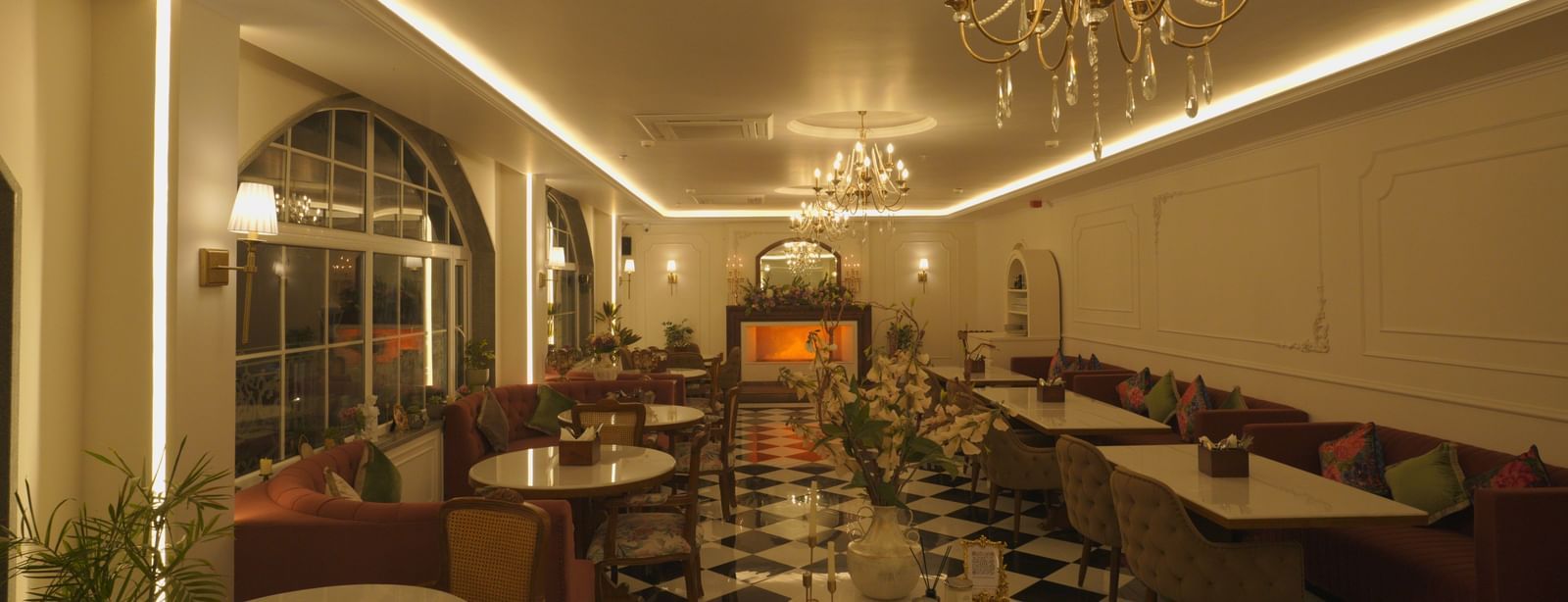 Elegant dining hall with chandeliers, arched windows, and chequered flooring - Mayfair Cafe & Suites, Dalhousie