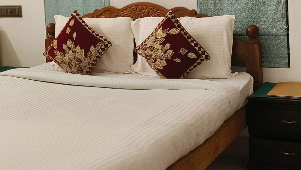 A zoomed in view of a double bed in the 104 room at Ananda Holiday Home, Wayanad 2