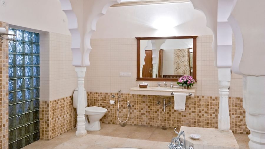 A bathtub in the centre of the room with a mirror in the background in the bathroom inside the suite - Mandawa Haveli, Jaipur