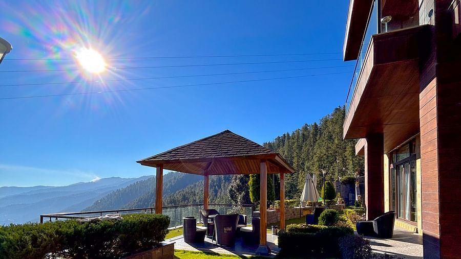 Sunny day view of a peaceful gazebo surrounded by Himalayan hills at Aranya Retreat, Mashobra