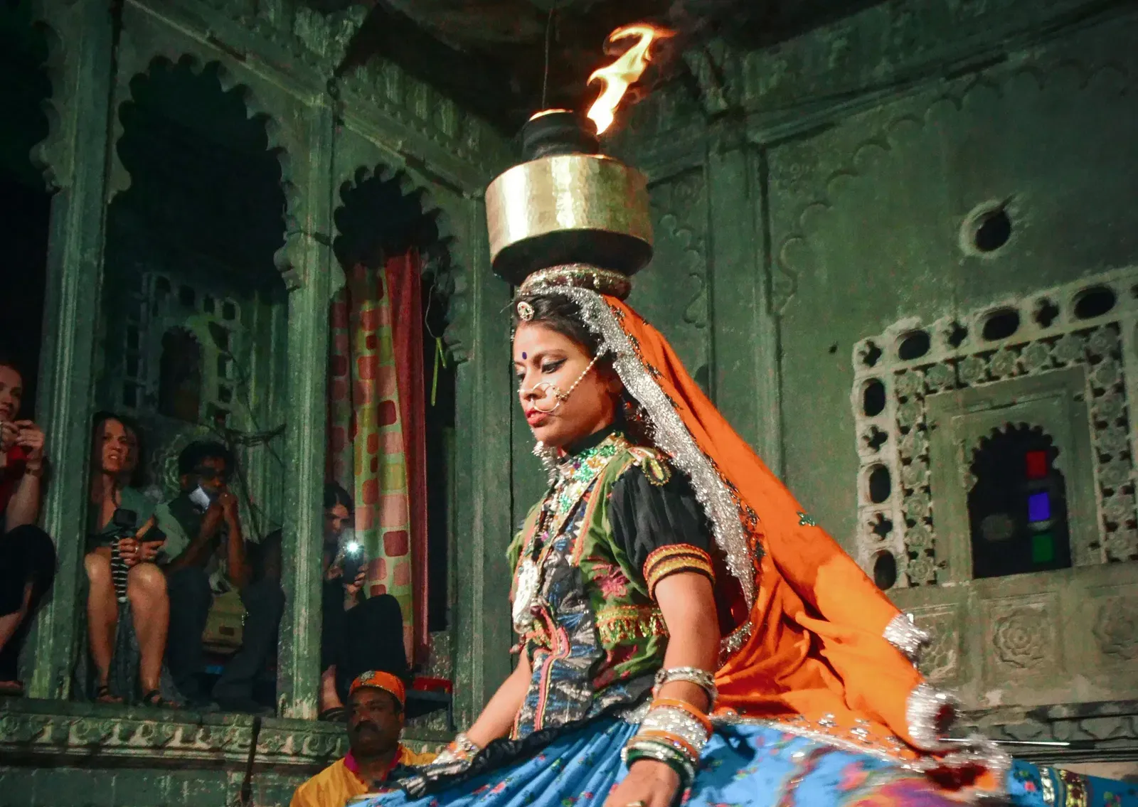 A woman dancer performing at Bagore Ki Haveli Cultural Show while balancing a pot on her head.