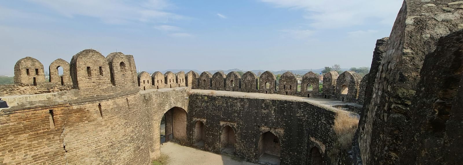 Outer stone walls and bastions of a historic fort with open courtyards.