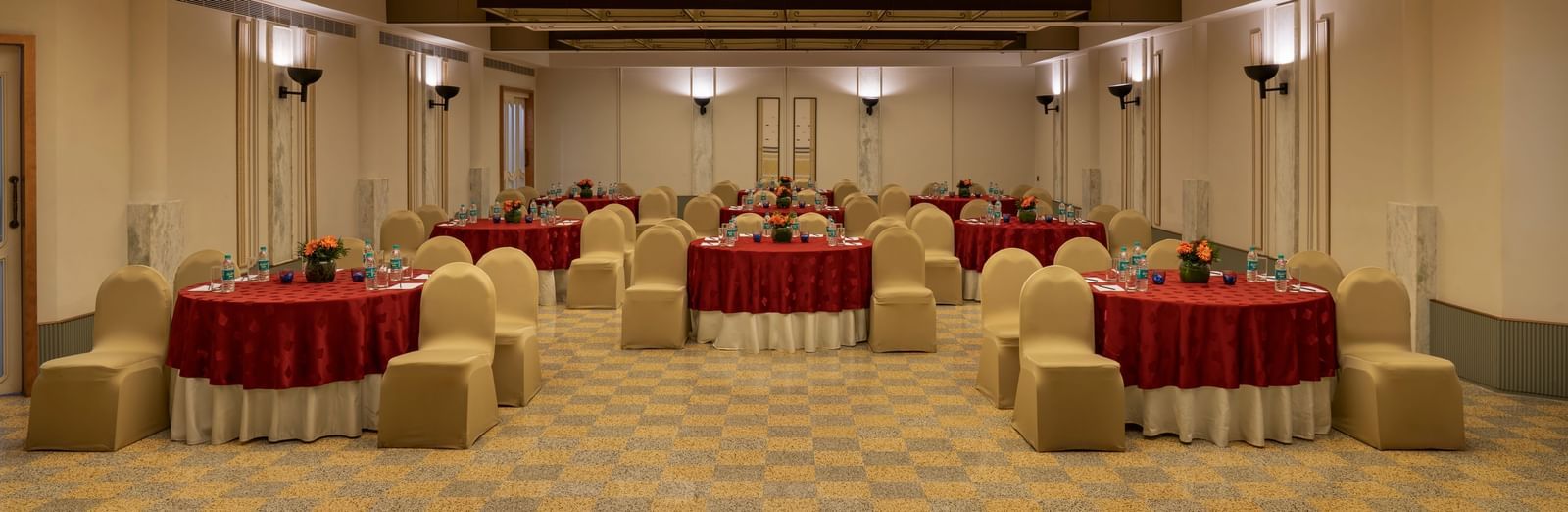  A banquet hall at Shilton International, Kochi, set with round tables and chairs for a gathering.