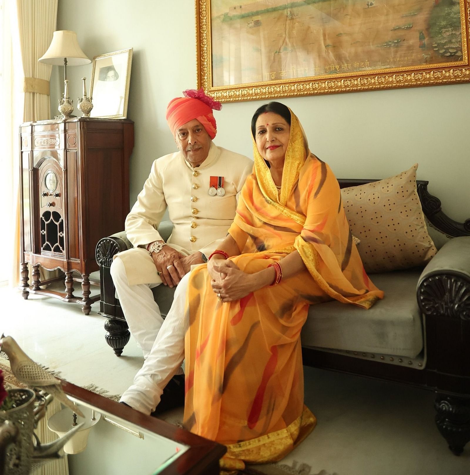 Mrs. Vinay Kumari & Mr. Umaid Singh Karansar sitting on a sofa in the lounge at Dileep Kothi, Jaipur