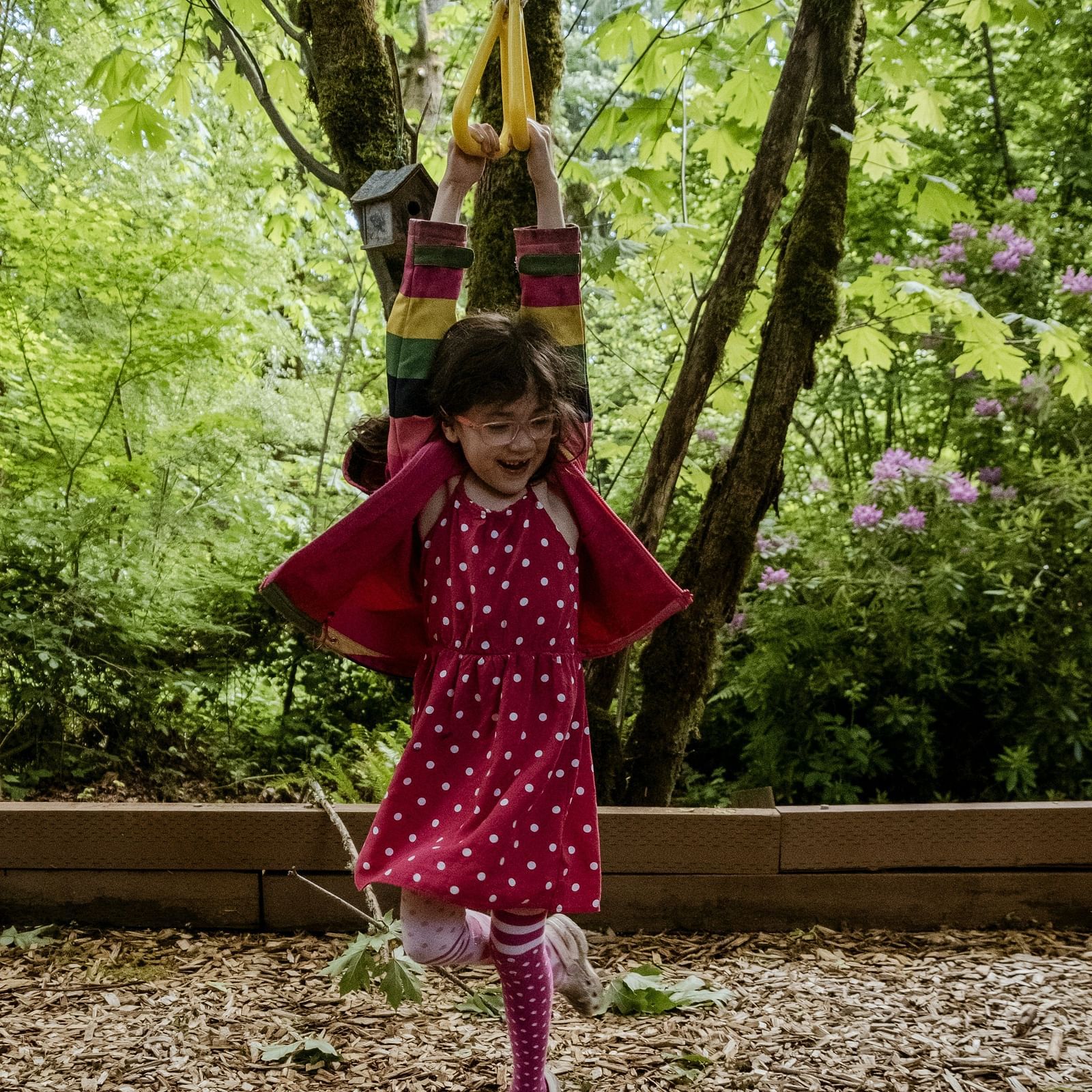 An overview of child playing in a playground with greenery in the background