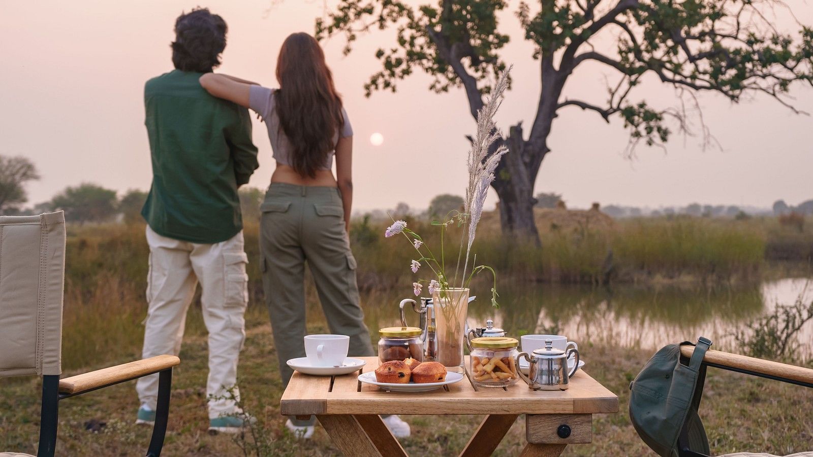 Couple watching a sunset with a dining setup at Trees N Tigers, Tadoba.