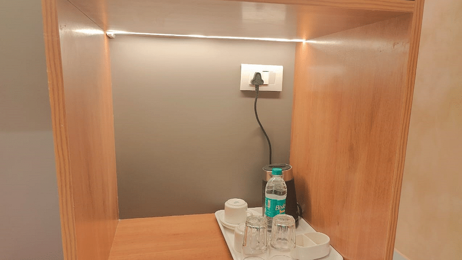 a tea and coffee maker placed on a stand 