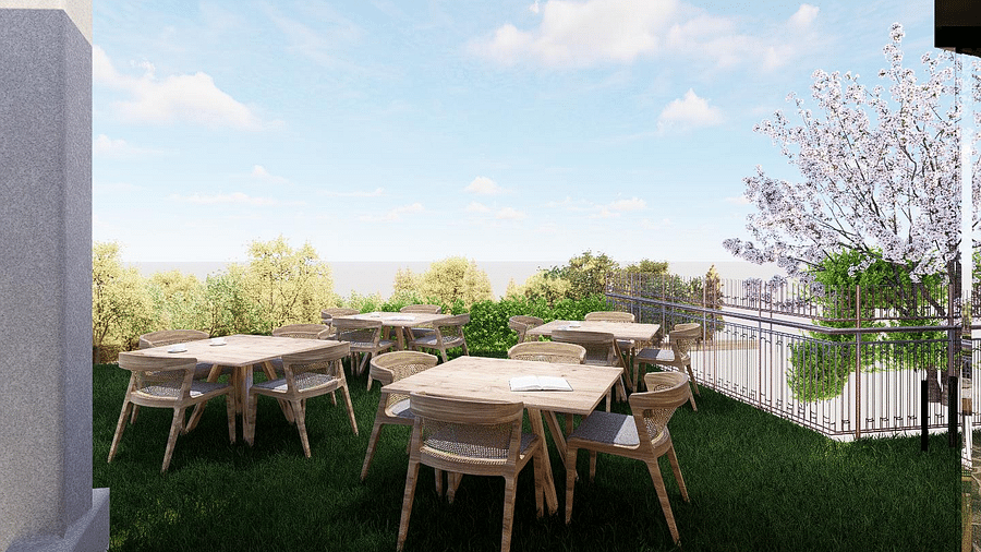 Open-air dining area surrounded by trees and plants with the sky overhead at The Evren, Vagator.