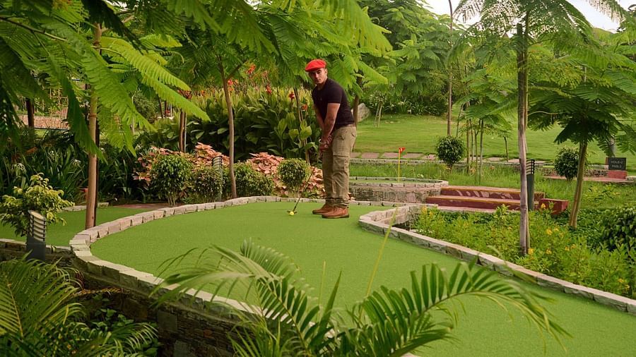 a person playing gold inside the golf course - ananta udaipur 