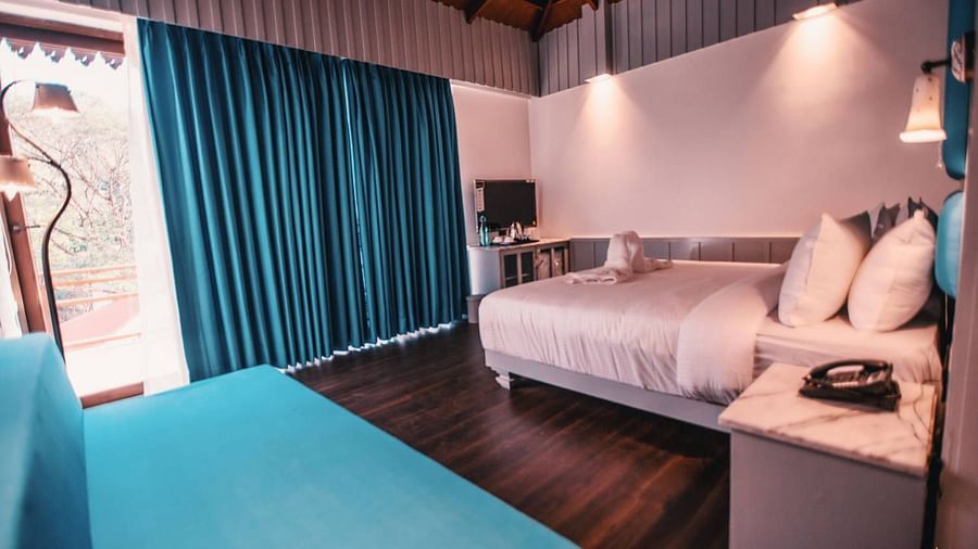 room with a king size bed and an expansive window overlooking the beautiful surroundings - Symphony Samudra Beachside Jungle Resort And Spa, Port Blair