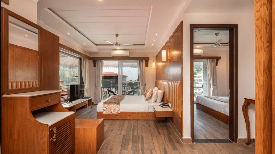 A family suite with a king size bed, a wardrobe, wooden furnishings, and a television at Quality Inn.