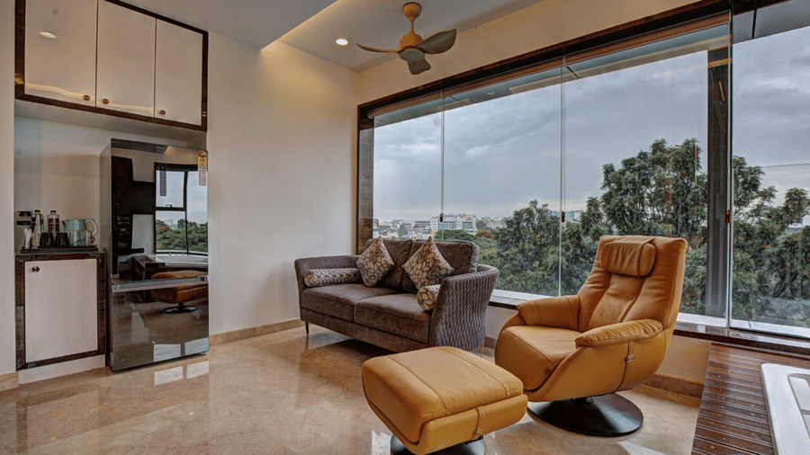 Corner view of the living room of the Grand Suite with ample of natural light coming from the window at SRS Suites, Koramangala.