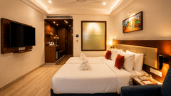 Deluxe Twin Room with Balcony at Sobit Sarovar Portico, Goa offering twin beds, contemporary interiors, private balcony, flat-screen TV, minibar, seating area and thoughtful amenities for a relaxing stay.
