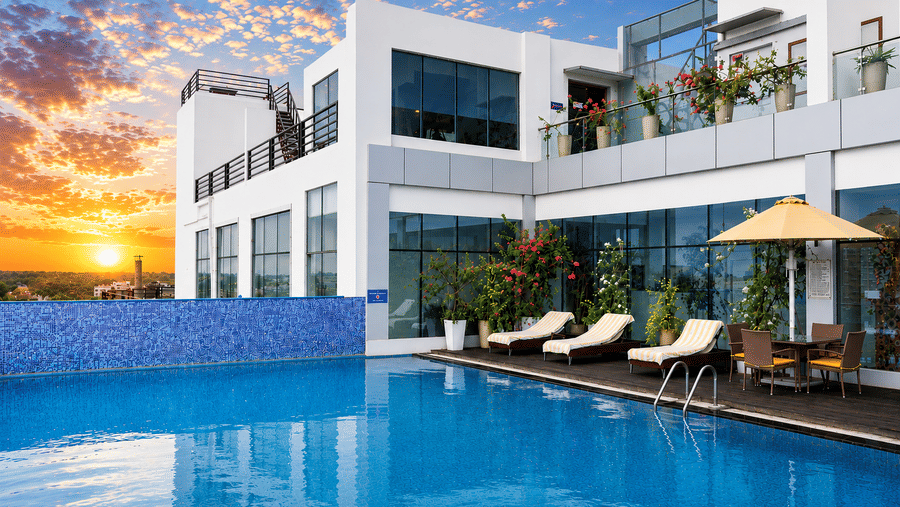 rooftop infinity pool overlooking a coastal city skyline under a bright, sunny sky. This type of architectural feature is commonly found at high-end hotels and luxury residential complexes in Golden Tulip, Lucknow .