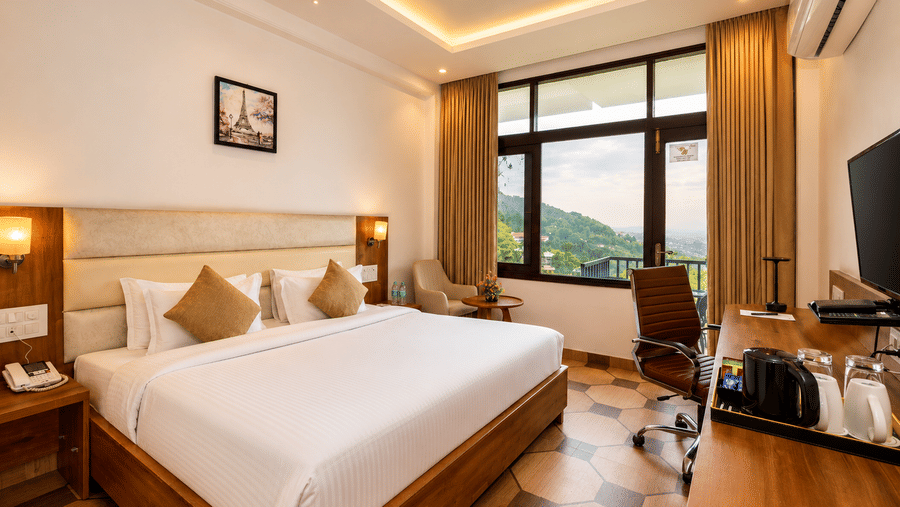 Inviting guest room with large windows and scenic views at Pride Ashiyana Resort Mussoorie.