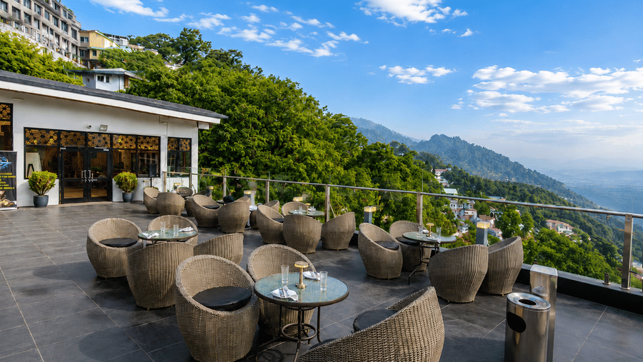 Open-air terrace seating with scenic mountain views at Pride Ashiyana Resort Mussoorie.