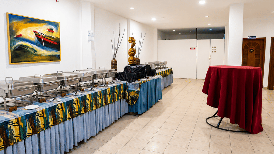 Pre Function Area buffet counter with chafing dishes and elegant red table linen at Chariot Beach Resort, ideal for events and gatherings.