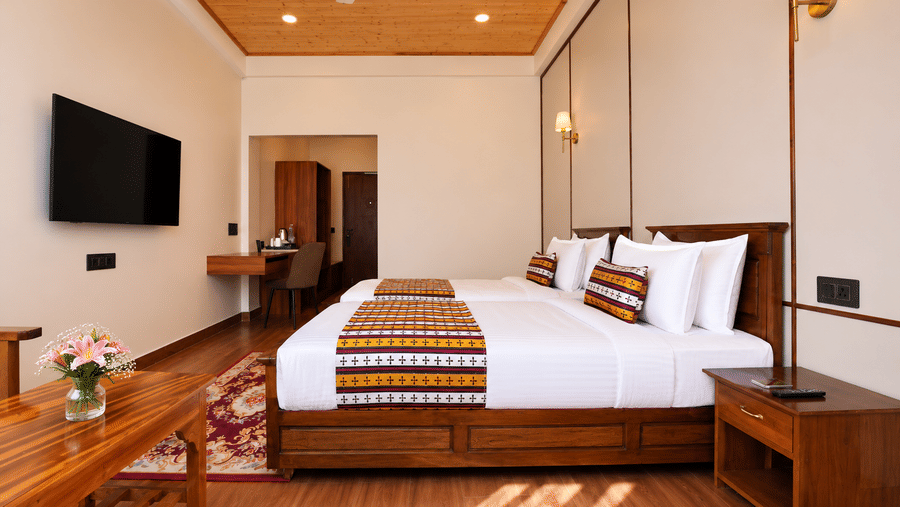 Premium Twin room at Summit Rungkhung Village Resort - The Signature Collection displays a double bed with pillows, side tables with lamps, a television mounted on the wall, and a desk area.