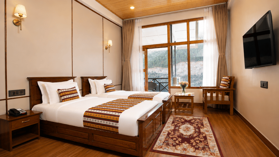 Premium Twin room at Summit Rungkhung Village Resort - The Signature Collection shows twin beds, nightstands, wall-mounted lamps, a television, a floor rug, and windows covered by curtains.