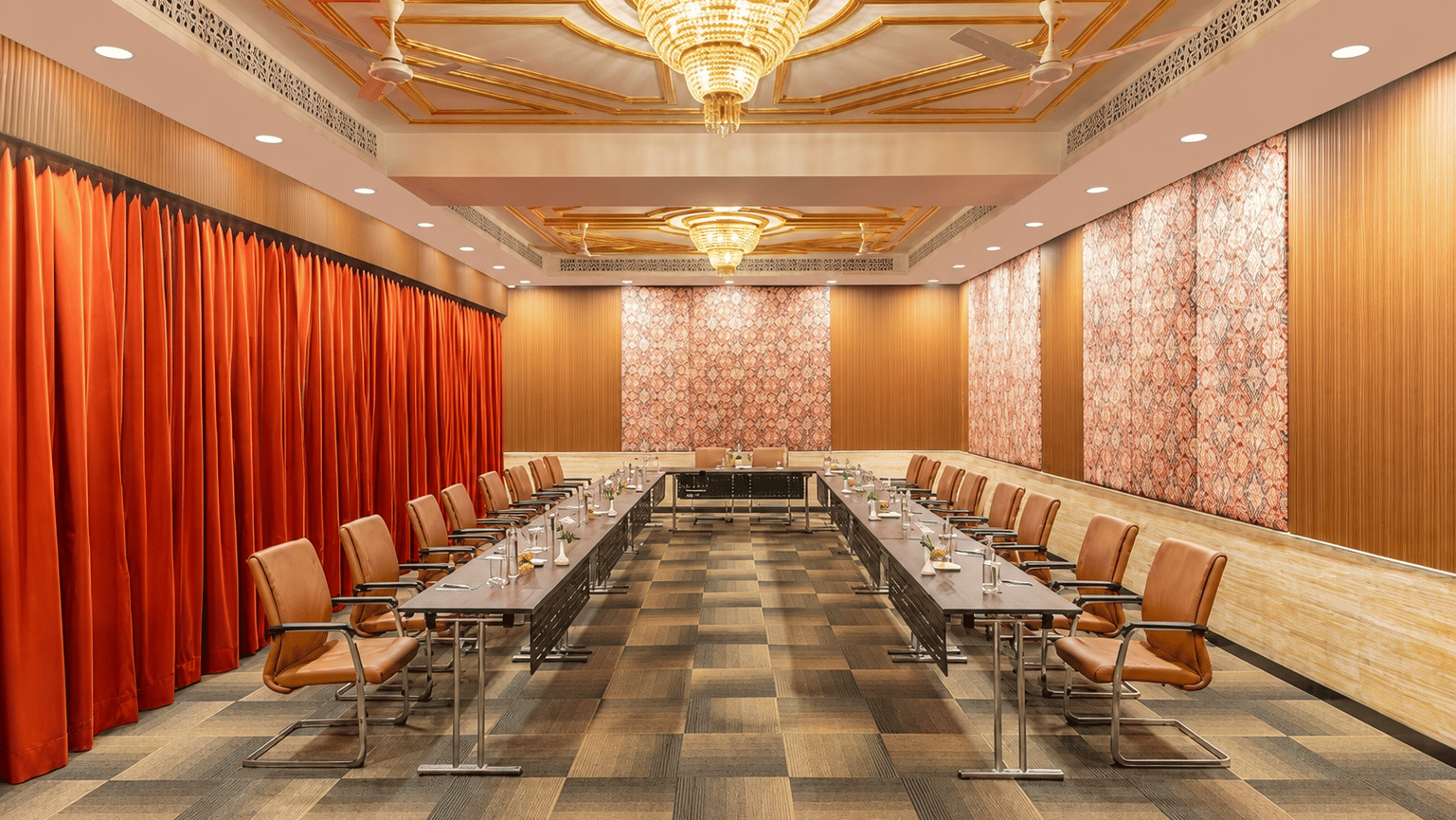 Conference hall with long boardroom table and red drapes at MAYFAIR Palm Beach Resort, Gopalpur-on-Sea