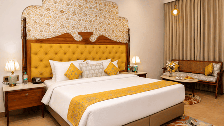 kadamb kuteer, vrindavan, featuring an elegant bedroom with a king-size bed, ornate headboard, traditional decor, and warm lighting