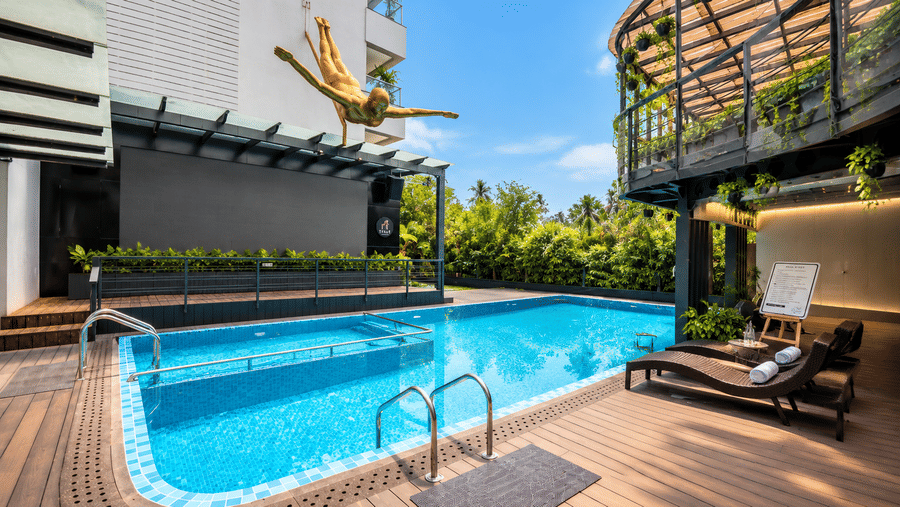 An outdoor swimming pool with sun loungers on a wooden deck at BluSalzz Collection - Casa Onze, Arpora.