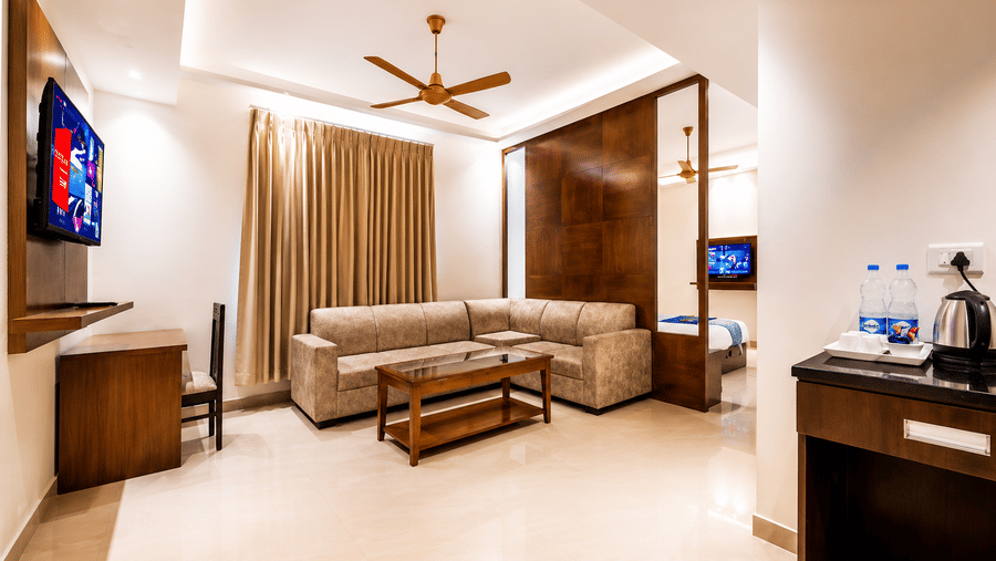 Executive Room with Living Area featuring a sofa, coffee table and television at Eastlynn Resort, Rishikesh.