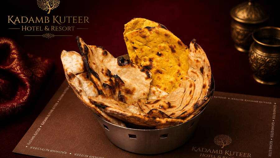 Dal baati churma served in a bowl with ghee on a branded placemat at Kadamb Kuteer, Vrindavan.
