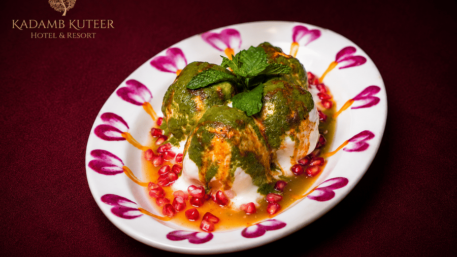 Plated paan dessert decorated with rose petals and pomegranate seeds at Kadamb Kuteer, Vrindavan.