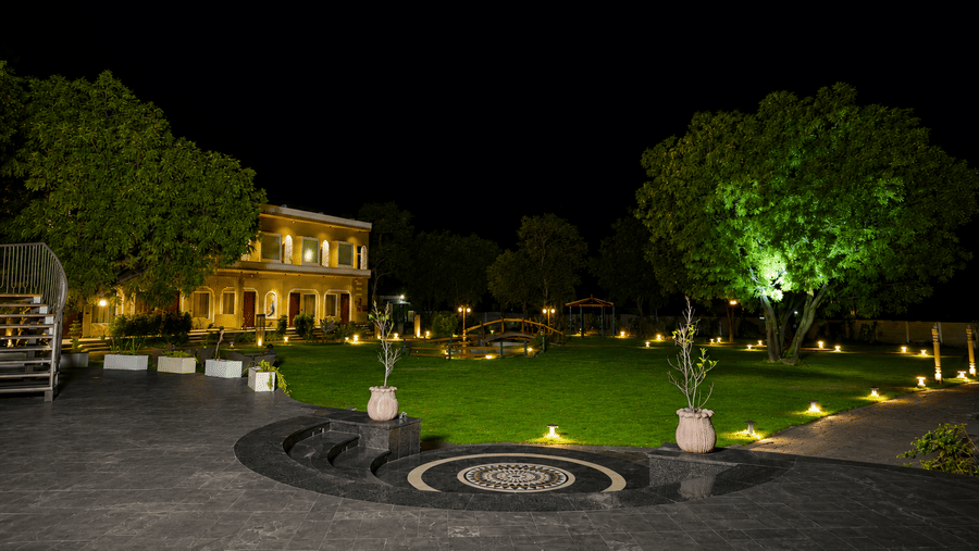 Heritage property building illuminated at night with manicured lawns and garden lighting at Kadamb Kuteer, Vrindavan.