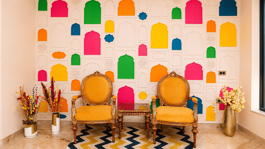 Hotel lobby with colourful lantern-shaped wall art, golden chairs, and a chevron-patterned floor at Kadamb Kuteer, Vrindavan.