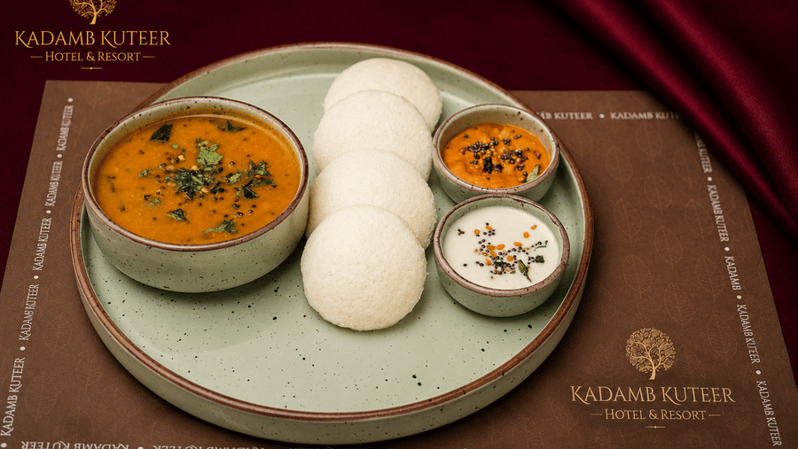 Idli served with sambar and coconut chutney on a plate at Kadamb Kuteer, Vrindavan.