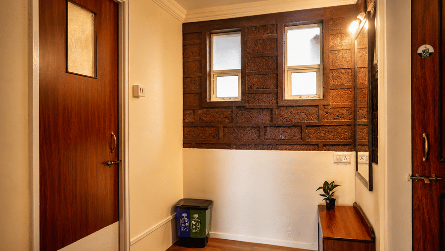 Wooden doors, small windows, recycling bin, and low sideboard inside an entry corridor at Wind Chalet property.