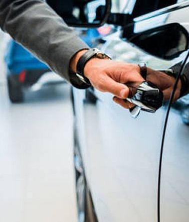 A man opening a door of a car.