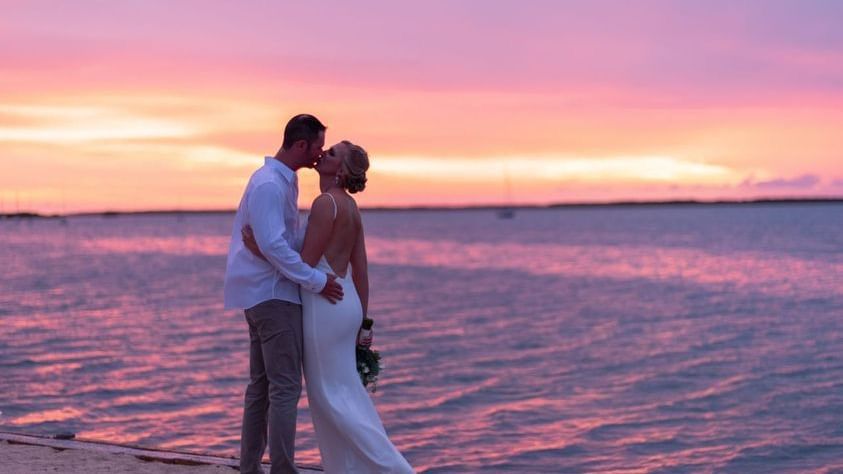 Bride and groom embracing by the ocean at sunset at Casa Morada.