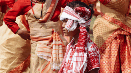 An eye-level medium shot captures a young boy participating in festival