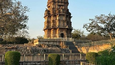 A tall, intricately carved tower rises against a clear sky.