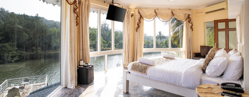 the Master Bedroom is equipped with large windows that offer an incredible view - Stone Wood Riverfront Resort, Siolim