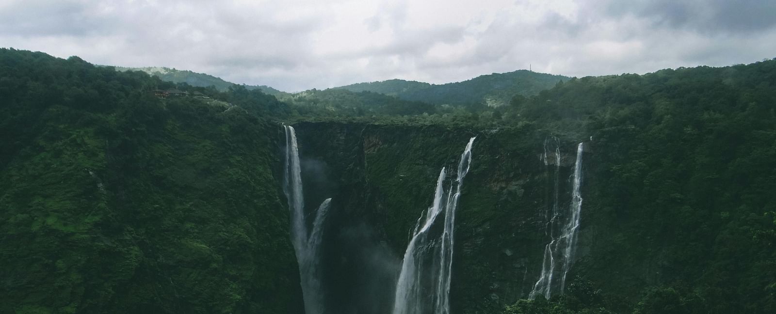 Jog Falls in Karnataka showing segmented waterfalls cascading from height with rocky cliffs and water streams.