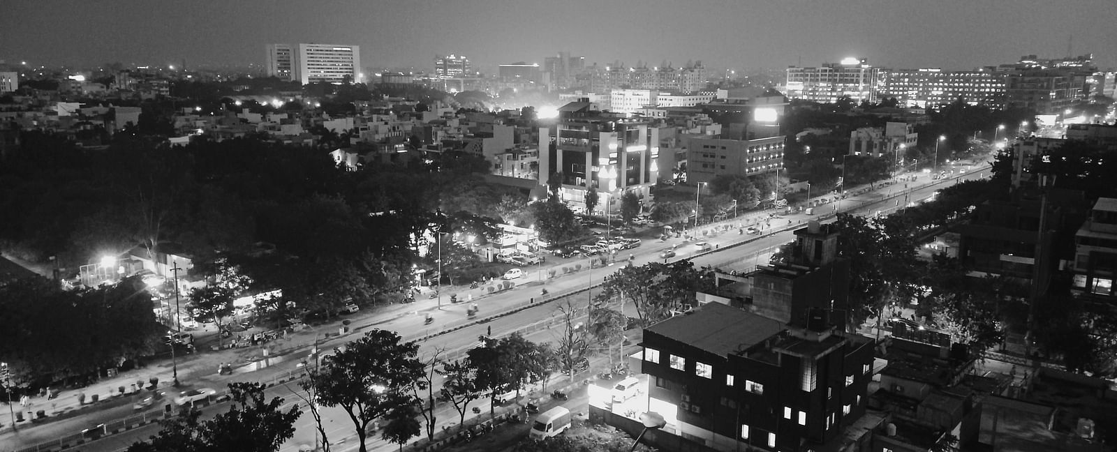 A grayscale aerial view of Indore at night with the lights on in the streets.