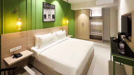 A hotel room with a large bed in front of a television - Wonder Hills