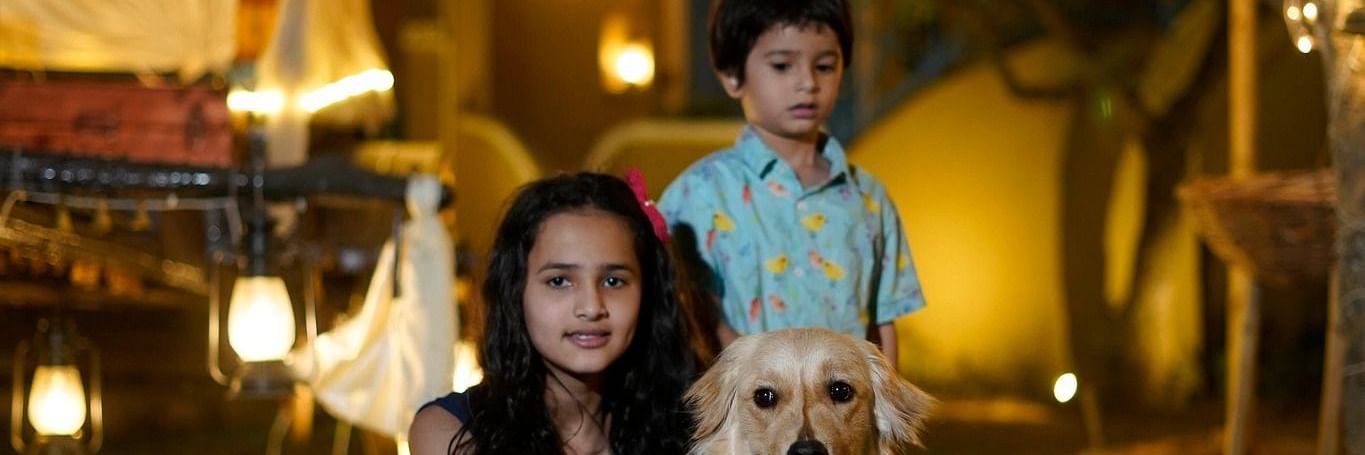 a woman and child sitting beside a dog at Themis Mudhouse - A Nature's Retreat Resort & Wellness
